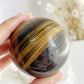 TIGERS EYE SPHERE APPROX 6.1CM. STONED AND SAGED AUSTRALIA.