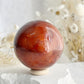 CARNELIAN SPHERE APPROX 6.1CM. STONED AND SAGED AUSTRALIA.