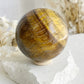 TIGERS EYE SPHERE APPROX 6.4CM. STONED AND SAGED AUSTRALIA.