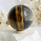 TIGERS EYE SPHERE APPROX 6.1CM. STONED AND SAGED AUSTRALIA.