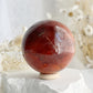 CARNELIAN SPHERE APPROX 6.1CM. STONED AND SAGED AUSTRALIA.