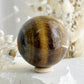 TIGERS EYE SPHERE APPROX 6.4CM. STONED AND SAGED AUSTRALIA.